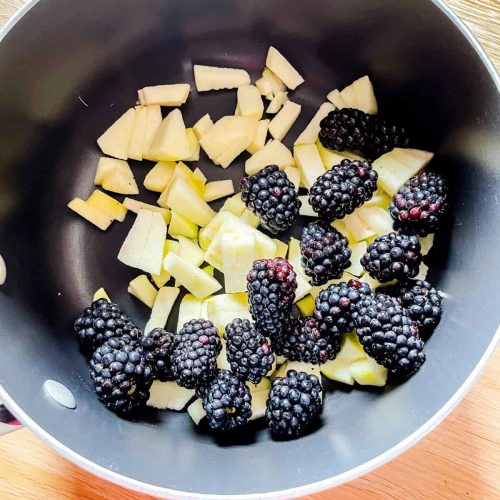 blackberries and apple pieces in saucepan