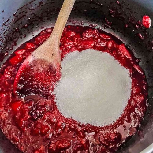 Add sugar to blackberries and apple