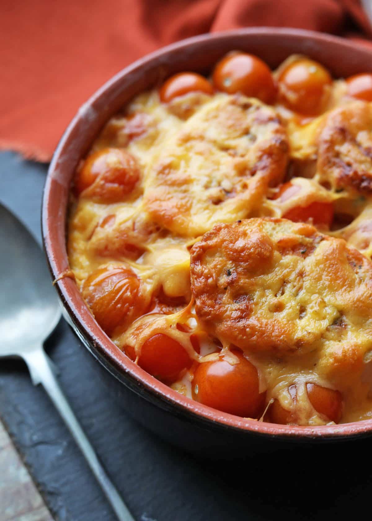 Garlic Bread and Tomato Bake in serving dish with spoon