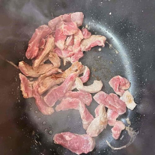 Slow cooker massaman curry beef searing in pan
