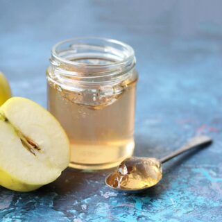 Apple Jelly in jar with apple and spoon
