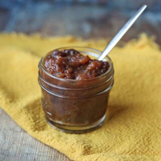 Slow Cooker Date and Apple Chutney with a spoon in the jar