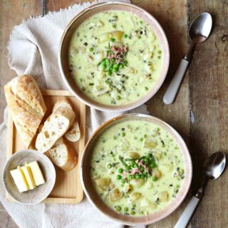 Two bowls of soup with bread and butter