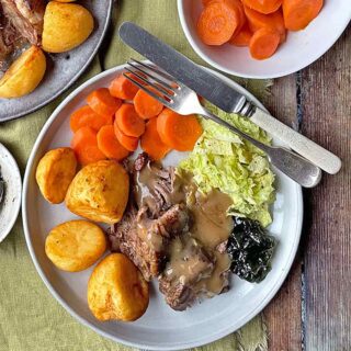 Plate of lamb with gravy and vegetables