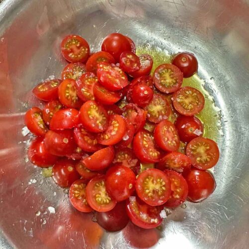Air fryer sun dried tomatoes, cut tomatoes in bowl with oil and salt