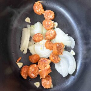 Slow cooker Baked beans and chorizo. onions, oil and chorio in slow cooker