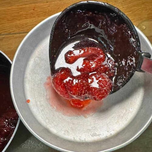 ladle stgrawberry jam into jars