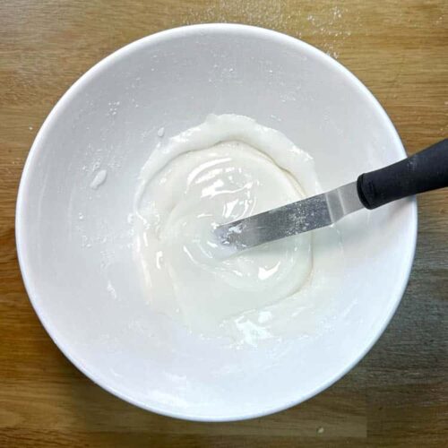 mixed icing sugar and water in bowl with spatula.