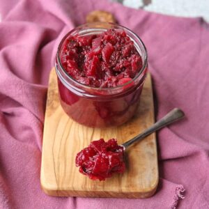 beetroot chutney in jar with chutney on spoon.