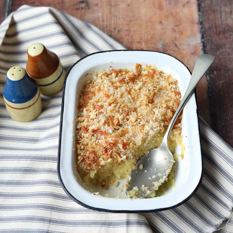 cheesy parsnip gratin with spoon on striped linen.