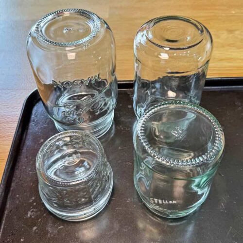 glass jars on baking tray.