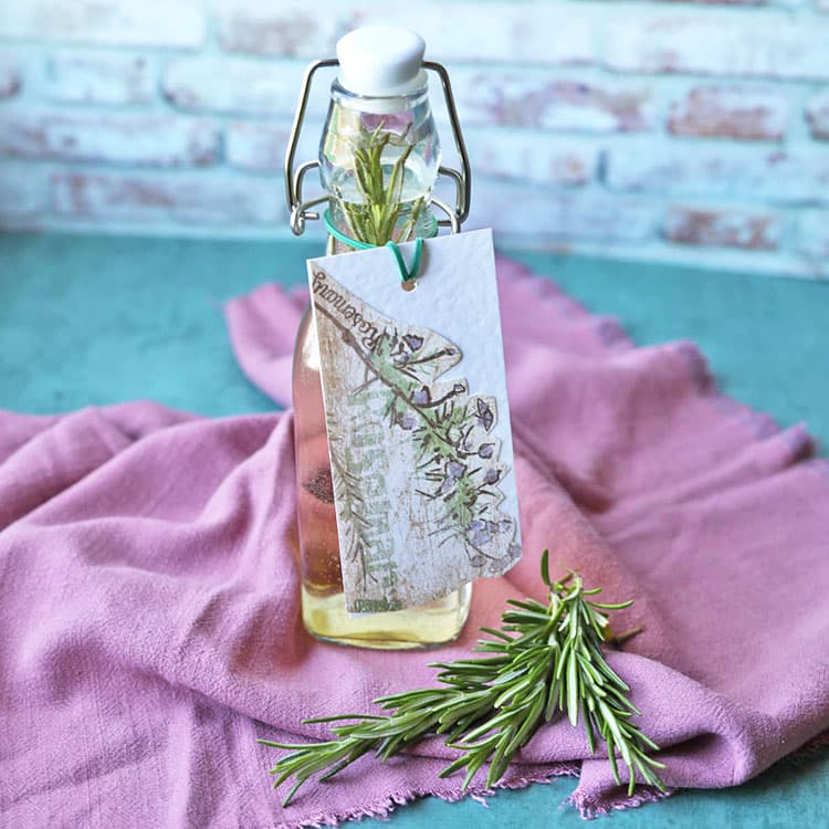 rosemary vinegar in bottle with sprig of rosemary.