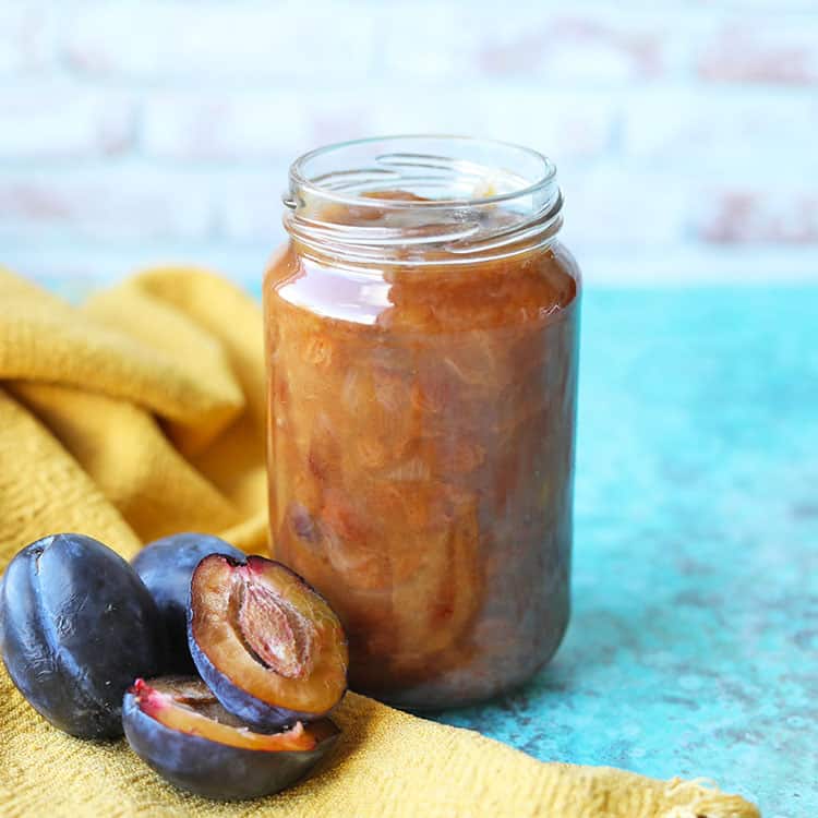 simpel plum chutney in jar with plums on side.