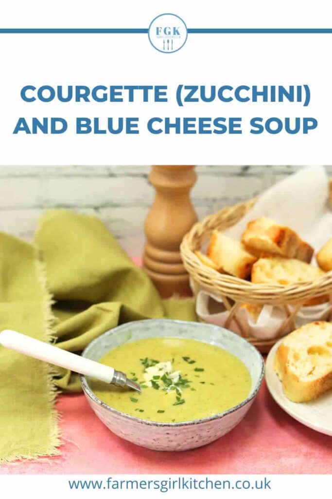 bowl of courgette (zucchini) and blue cheese soup with bread, spoon in bowl.